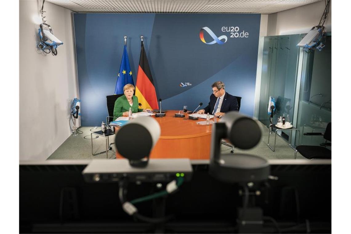 Bundeskanzlerin Angela Merkel (l) und Markus Söder bei der Videokonferenz mit Länderregierungschefs. Foto: Steffen Kugler/Bundesregierung/dpa