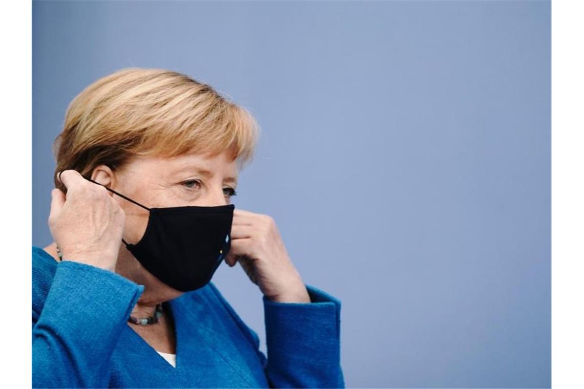 Merkel stimmt Bürger auf schwierige Corona-Zeiten ein Bundeskanzlerin Angela Merkel nimmt vor ihrer traditionellen Sommer-Pressekonferenz zu aktuellen innen- und außenpolitischen Themen ihre Maske ab. Foto: Michael Kappeler/dpa-Pool/dpa