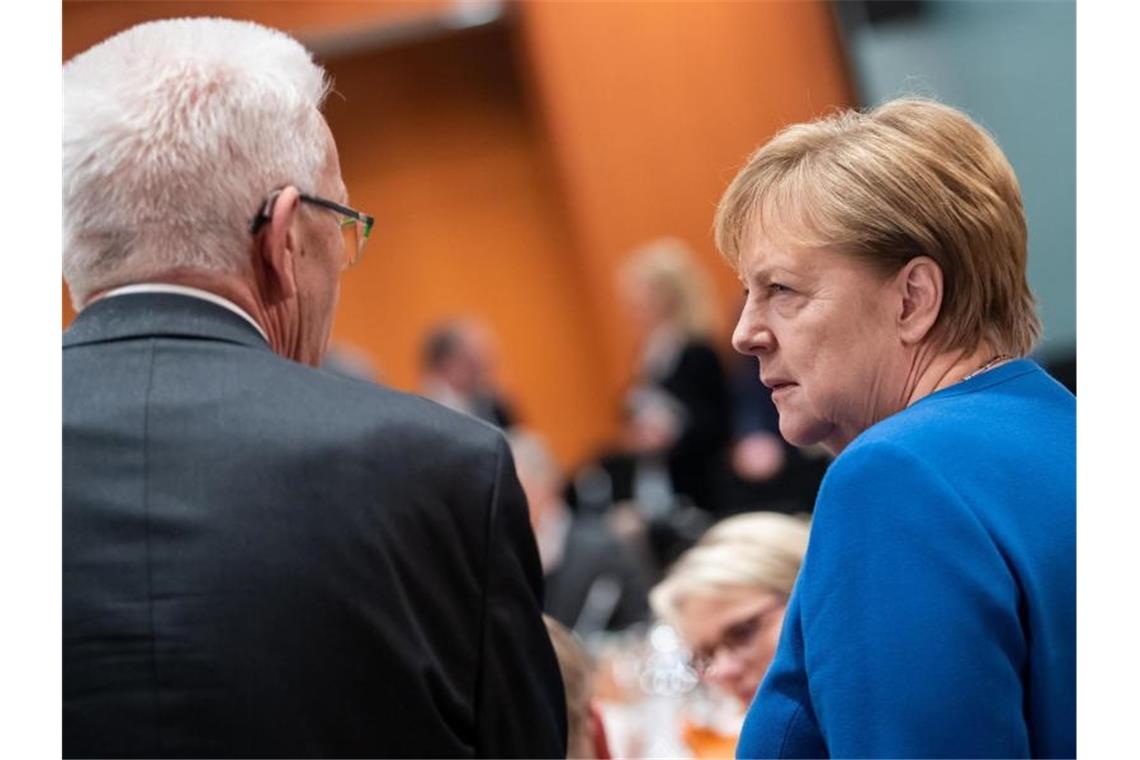 Bundeskanzlerin Angela Merkel (r, CDU) im Gespräch mit Winfried Kretschmann (Grüne). Foto: Bernd von Jutrczenka/dpa/Archivbild
