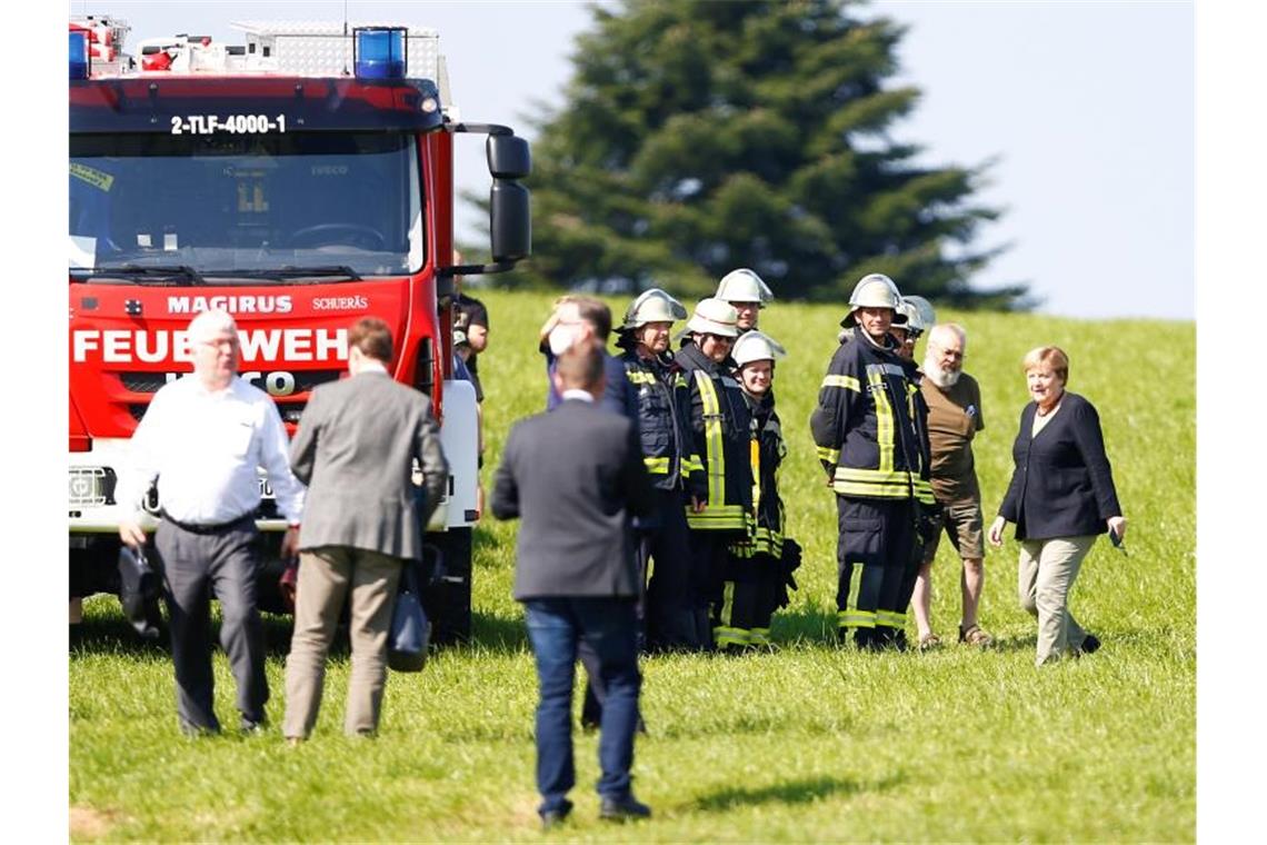 Merkel und Laschet in den Flutgebieten Bundeskanzlerin Angela Merkel trifft Kollegen zweier im Hochwasser-Einsatz gestorbener Feuerwehrleute in Schalksmühle. Foto: Thilo Schmuelgen/Reuters Pool/dpa