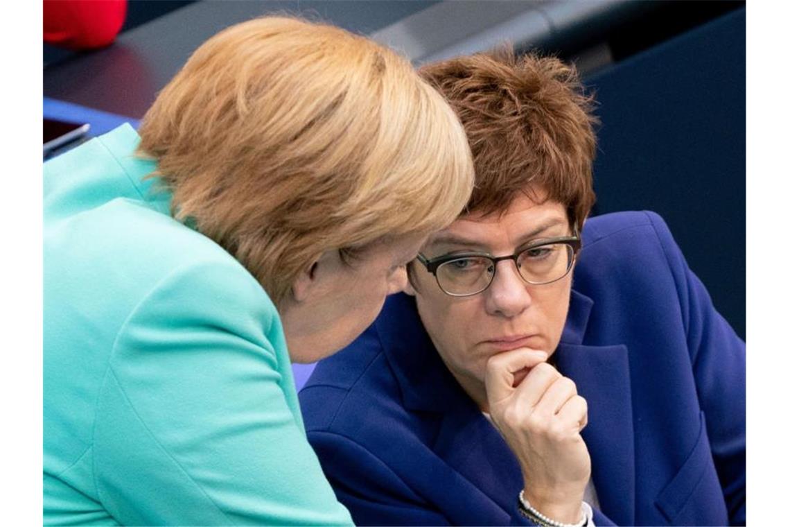 Bundeskanzlerin Angela Merkel und Annegret Kramp-Karrenbauer während einer Bundestagssitzung. Foto: Kay Nietfeld/dpa/Archiv