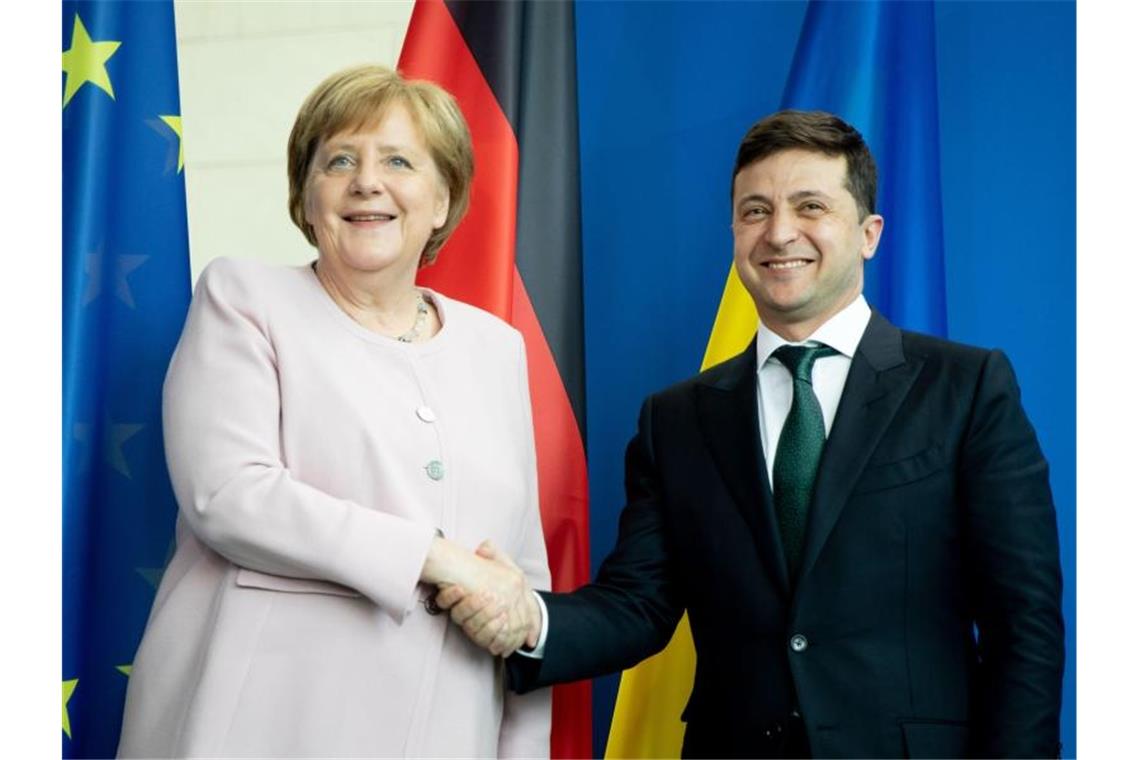 Bundeskanzlerin Angela Merkel und der ukrainische Präsident Wolodymyr Selenskyj reichen sich nach einer Pressekonferenz die Hände. Foto: Kay Nietfeld