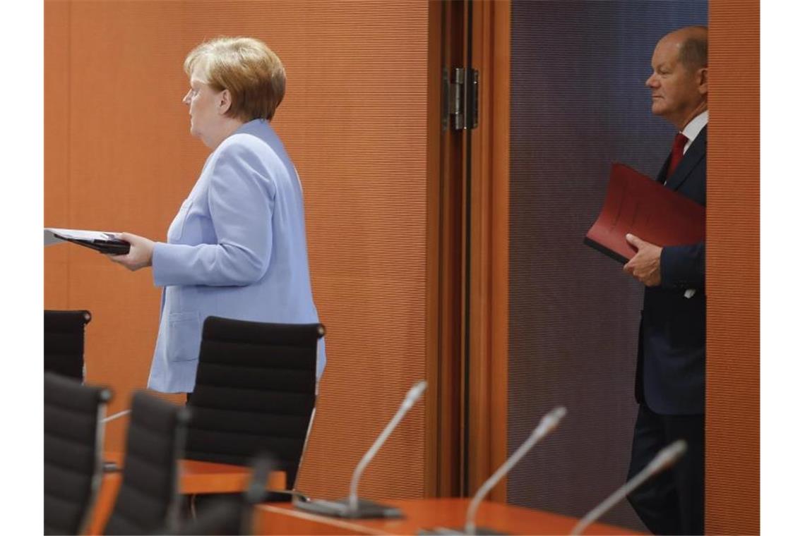 Bundeskanzlerin Angela Merkel und Vizekanzler Olaf Scholz kommen zur Sondersitzung des Kabinetts. Foto: Markus Schreiber/AP/POOL//dpa