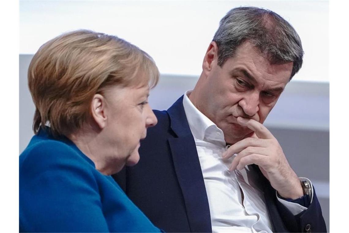 Bundeskanzlerin Merkel spricht mit Markus Söder 2019 beim 32. CDU-Bundesparteitag. Foto: Michael Kappeler/dpa