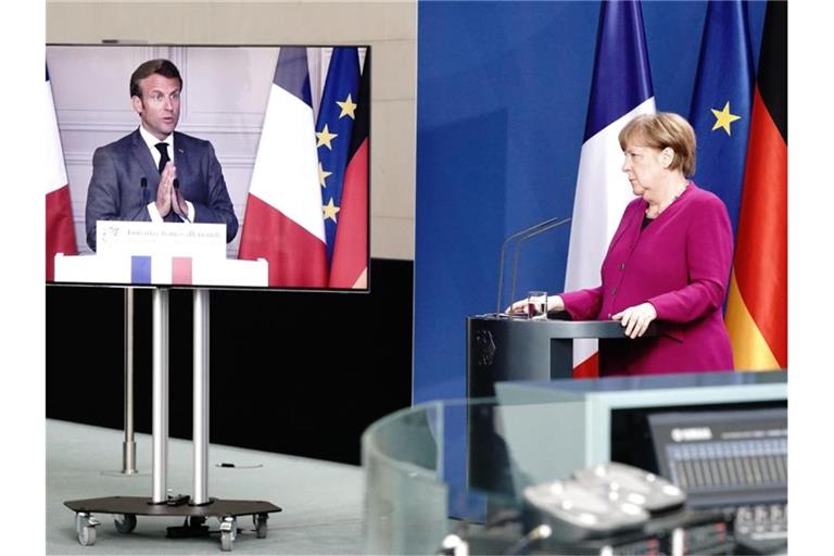 Bundeskanzlerin Merkel und Emmanuel Macron bei einer Pressekonferenz. Frankreichs Präsident ist per Video zugeschaltet. Foto: Kay Nietfeld/dpa-Pool/dpa