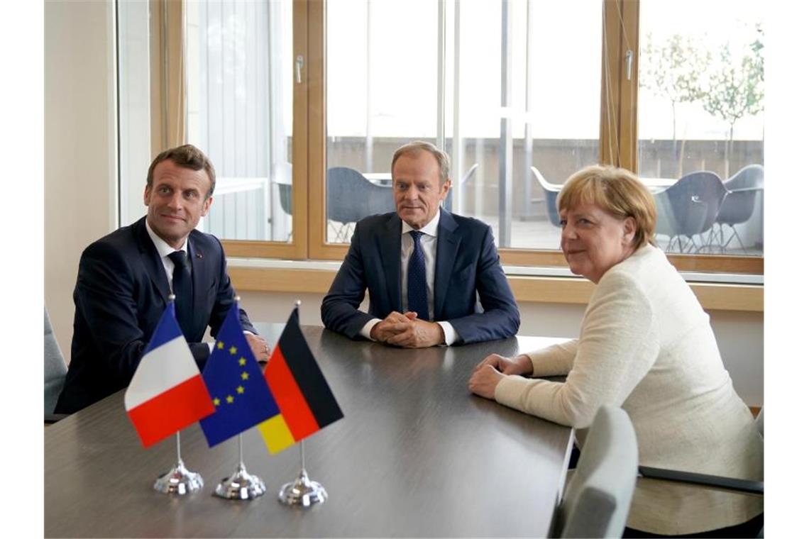 EU-Gipfel zerstritten über Klimaziel und Personalpaket Bundeskanzlerin Merkel und EU-Ratschef Tusk (M) dämpften die Hoffnung, dass man sich beim zweitägigen Gipfel bereits auf ein Personalpaket einigen könnte. Frankreichs Präsident Emmanuel Macron (l) ist gegen Manfred Weber als Kommissionspräsident. Foto: Kenzo Tribouillard/AFP Pool