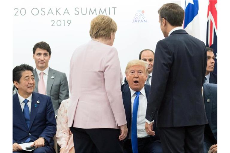 Bundeskanzlerin Merkel und Frankreichs Präsident Macron im Gespräch mit US-Präsident Donald Trump. Foto: Stefan Rousseau/PA Wire