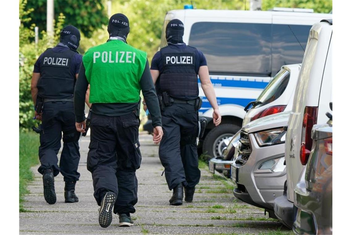 Bundespolizisten laufen vor einem Haus in Leipzig Grünau entlang. Foto: Peter Endig/dpa-Zentralbild/dpa