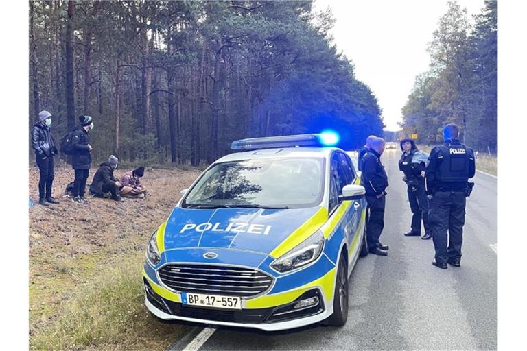 Bundespolizisten stehen neben einer Gruppe von Migranten, die zuvor über die deutsch-polnische Grenze gegangen waren. Foto: Danilo Dittrich/dpa-Zentralbild/dpa