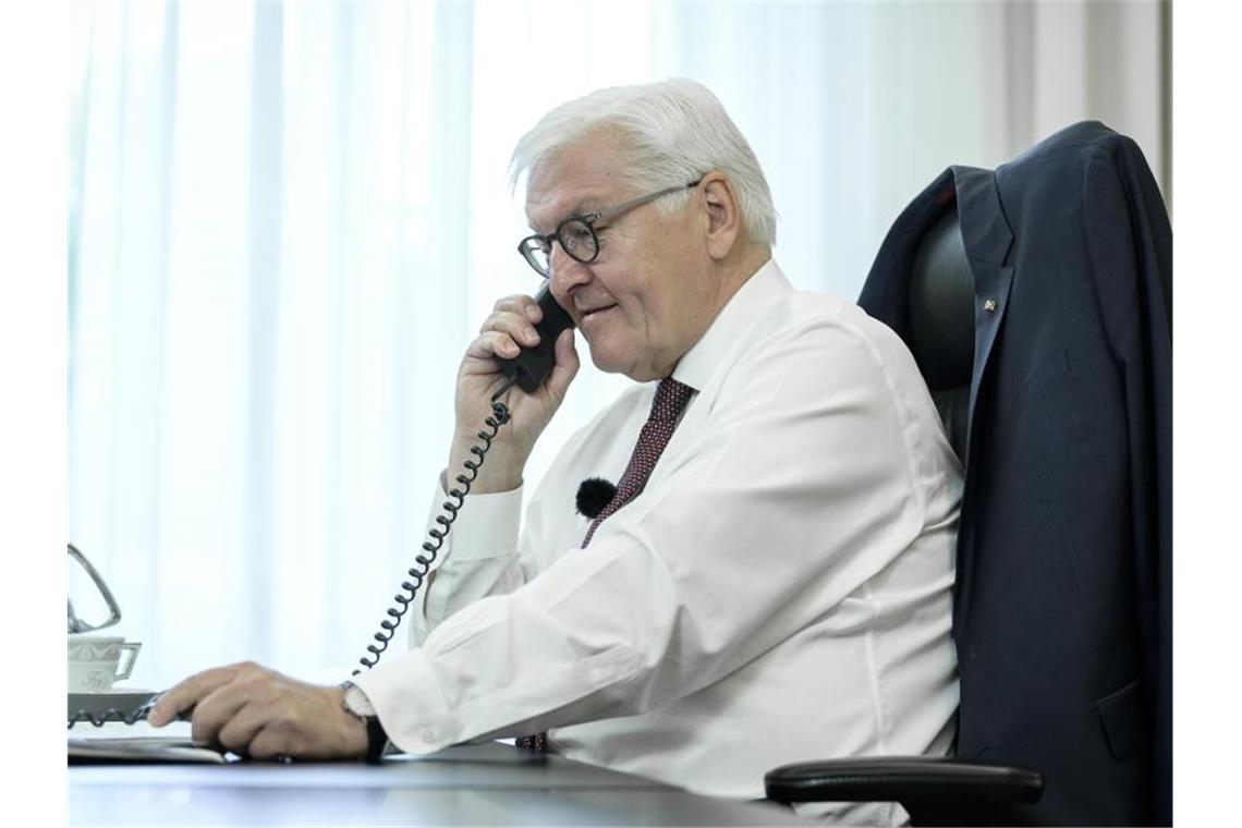 Bundespräsident Frank-Walter Steinmeier telefoniert an seinem Schreibtisch mit der Bewohnerin eines Altenheims in Bremen. Foto: -/Bundespresseamt-Pool/dpa