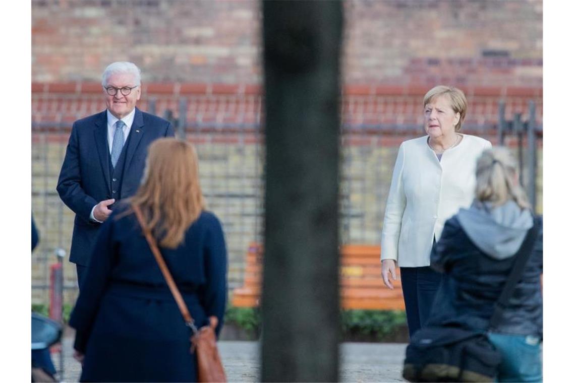 Bundespräsident Frank-Walter Steinmeier und Bundeskanzlerin Angela Merkel posieren für ein Foto vor der Kirche St. Peter und Paul in Potsdam. Foto: Christoph Soeder/dpa