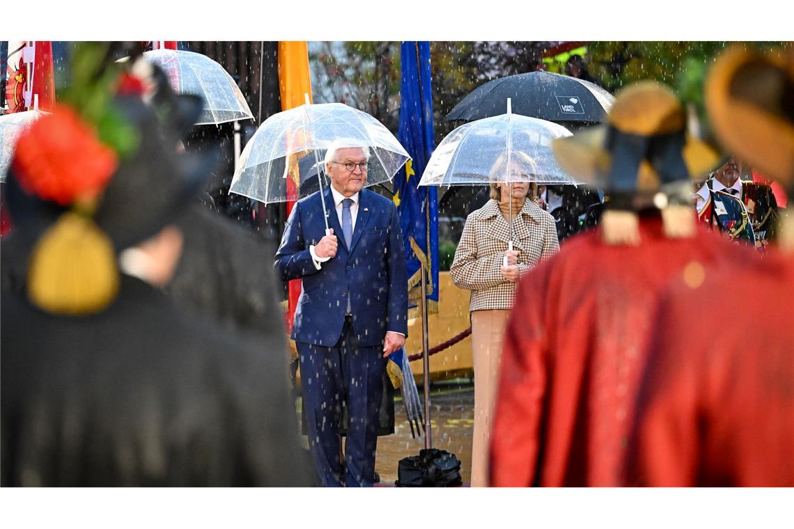 Bundespräsident Frank-Walter Steinmeier und seine Ehefrau Elke Büdenbender nehmen im strömenden Regen am landesüblichen Empfang durch die Tiroler Schützenkompanie teil.