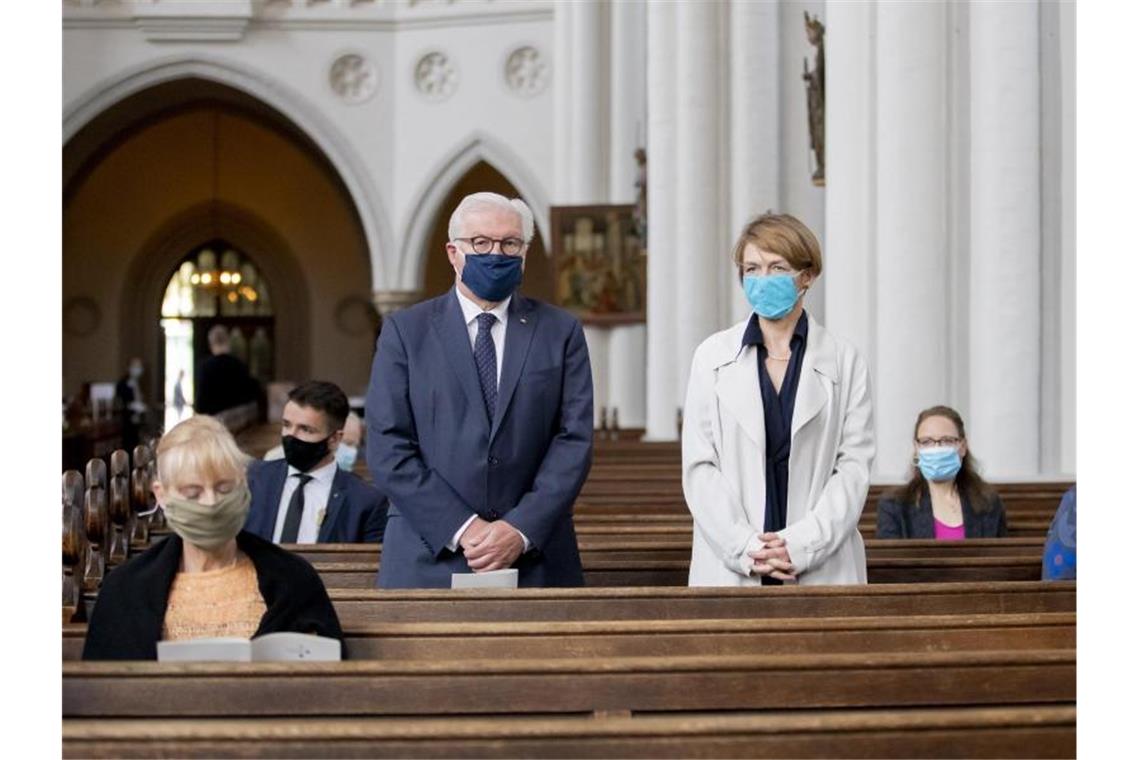 Bundespräsident Frank-Walter Steinmeier und seine Frau Elke Büdenbender stehen mit Mund-Nasen-Schutz in der evangelischen St. Marienkirche in Berlin-Mitte. Foto: Christoph Soeder/dpa