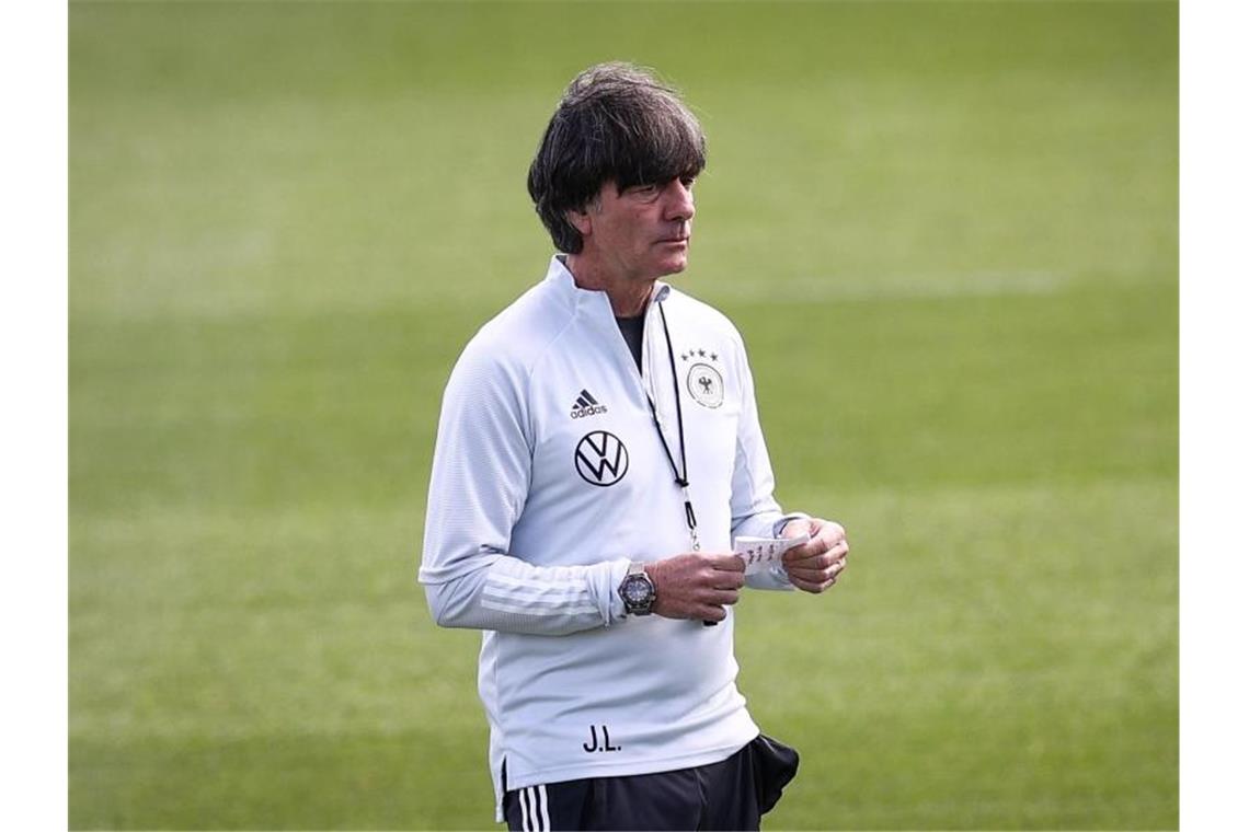 Löw sieht keine dunklen Wolken - Ginter: „Jetzt-erst-recht“ Bundestrainer Joachim Löw hält einen Zettel mit Notizen. Foto: Christian Charisius/dpa