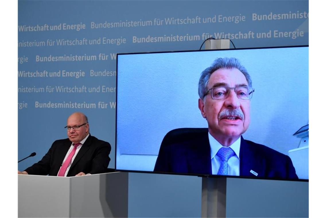 Bundeswirtschaftsminister Peter Altmaier (l) sitzt neben einer Leinwand, auf der BDI-Präsident Dieter Kempf zu sehen ist. Foto: John Macdougall/AFP-Pool/dpa
