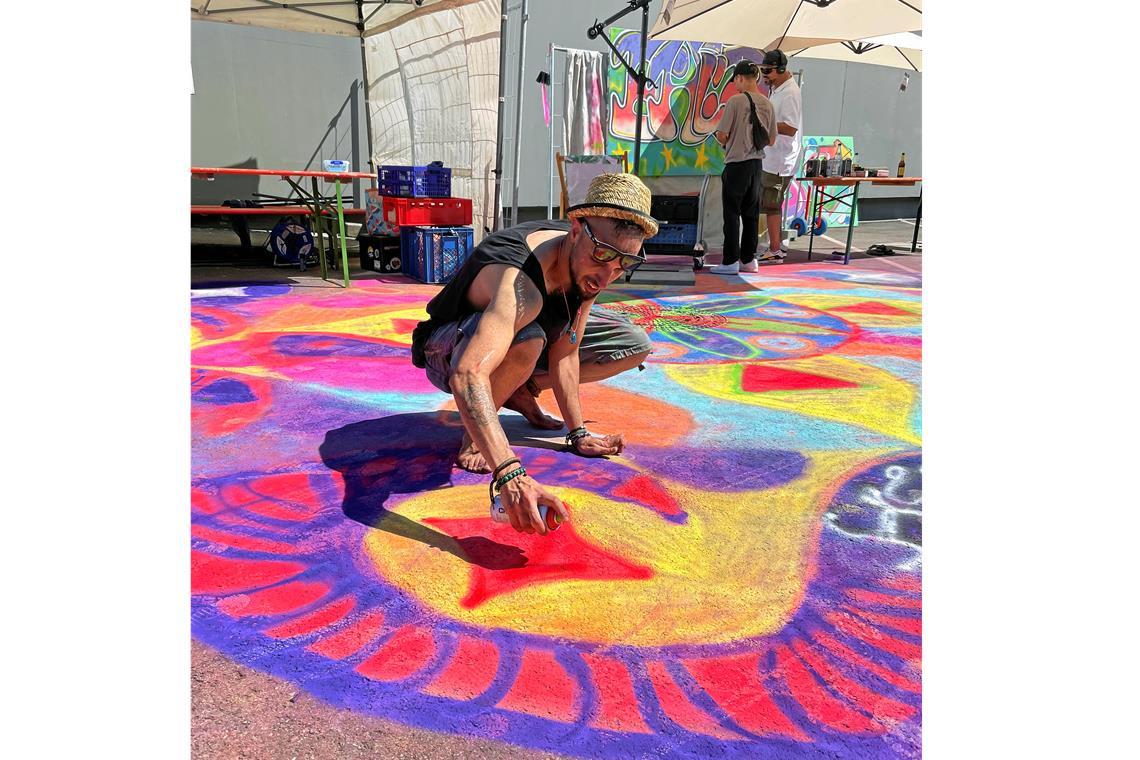 Der Live-Blog zum 53. Backnanger Straßenfest: Mit dem Zapfenstreich klingt das Fest aus Bunte Kunstwerke statt grauer Asphalt: Sina Jamshidi verschönert mit Sprühkreide den Müller-Parkplatz. Foto: K. Fritz