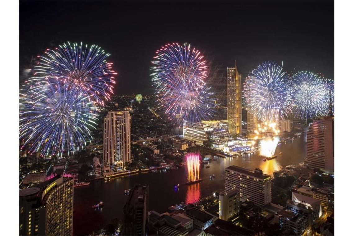 Bunte Raketen explodieren über dem Chao-Phraya-Fluss in Thailands Hauptstadt Bangkok. Foto: Wason Wanichakorn/AP/dpa