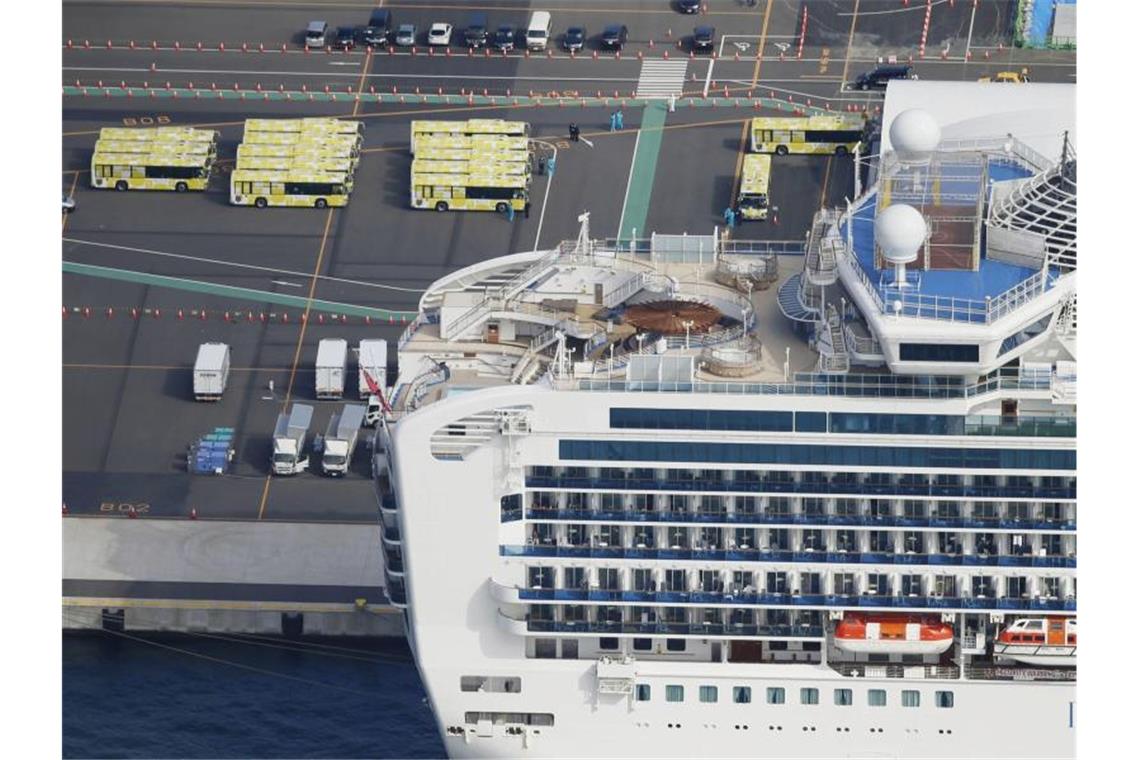 Busse werden in der Nähe des Kreuzfahrtschiffs „Diamond Princess“ geparkt. Die ersten Passagiere dürfen von Bord gehen. Foto: Yuta Omori/Kyodo News/dpa