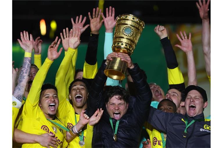 BVB-Coach Edin Terzic streckt den DFB-Pokal in den Berliner Nachthimmel. Foto: Martin Rose/Getty-Pool/dpa