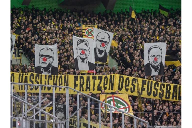 BVB-Fans zeigen Banner mit den Gesichtern von Rainer Koch (l-r), Christoph Schickhardt Dietmar Hopp, Fritz Keller und Karl-Heinz Rummenigge mit roter Clownsnase. Foto: Bernd Thissen/dpa/Archivbild