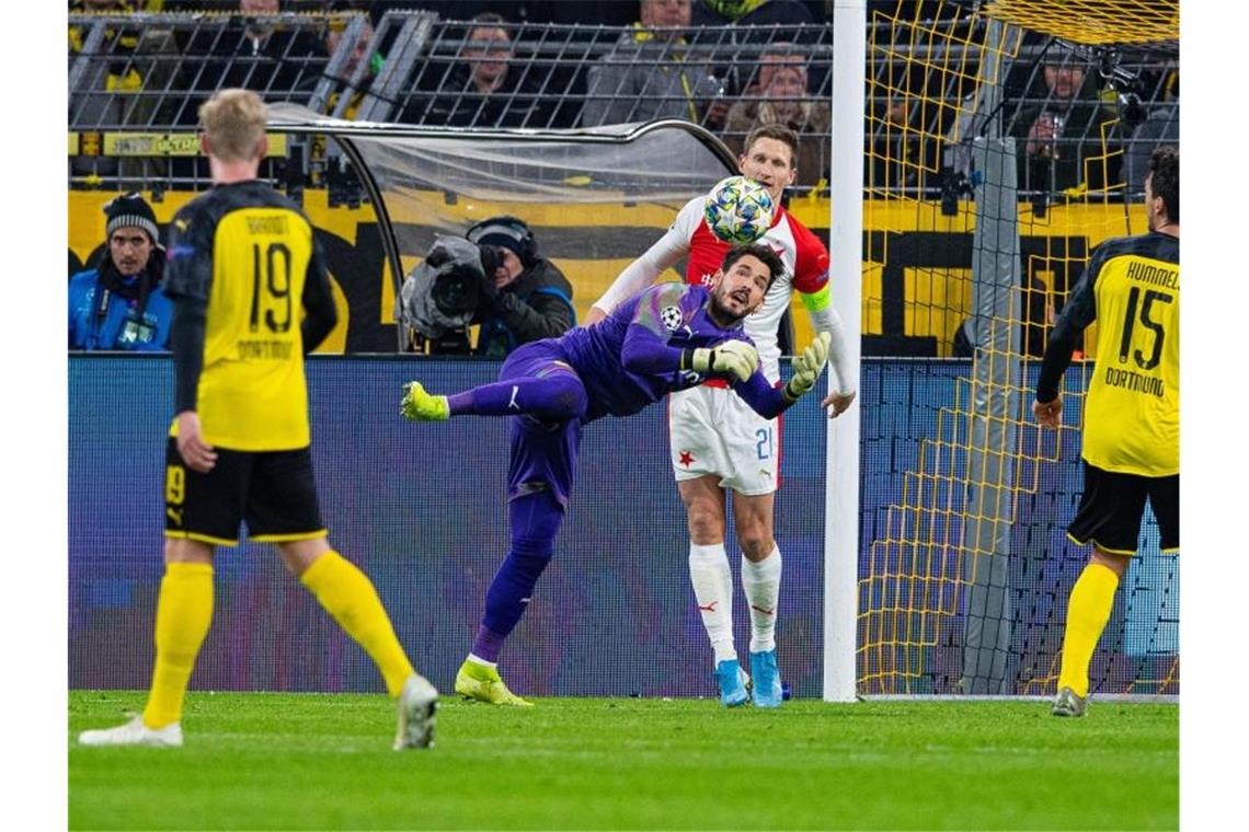 BVB-Keeper Roman Bürki (2.v.l) klärt vor Slavias Milan Skoda. Foto: Guido Kirchner/dpa