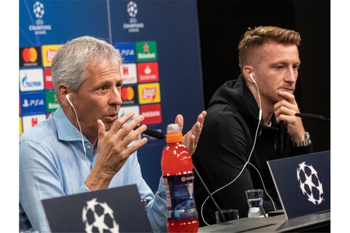 BVB-Trainer Lucien Favre (l) und Marco Reus bei der Pressekonferenz vor dem Spiel gegen den FC Barcelona. Foto: Bernd Thissen