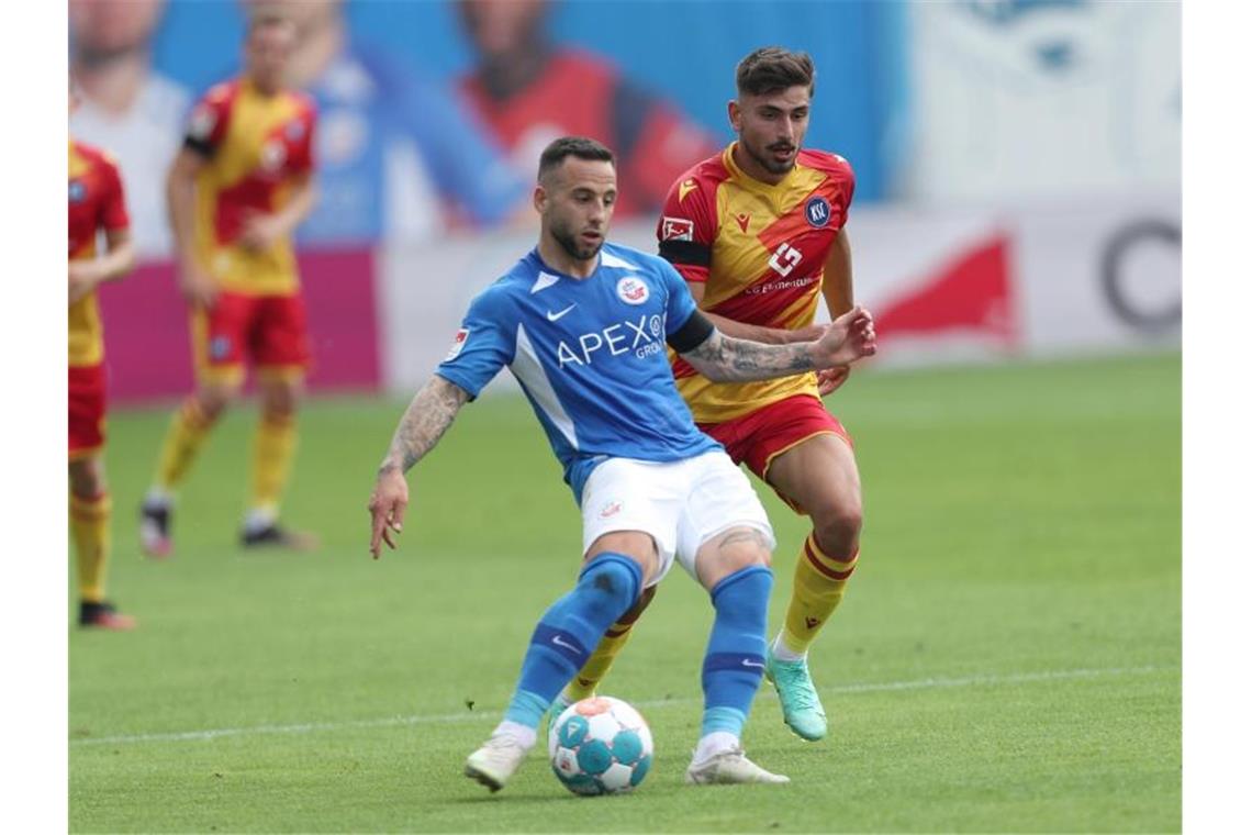 „Glück gehabt“: Karlsruher SC feiert Auftaktsieg in Rostock Calogero Rizzuto (l) vom FC Hansa Rostock im Kampf um den Ball mit Malik Batmaz vom Karlsruher SC. Foto: Danny Gohlke/dpa