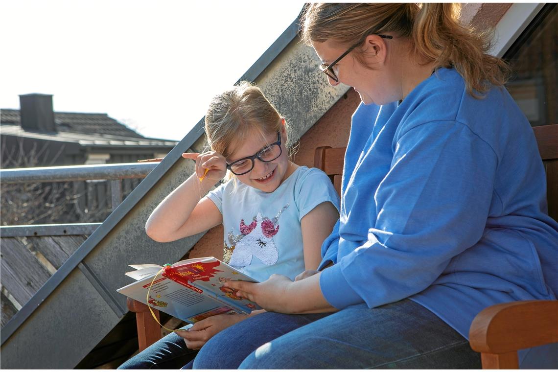 Carina Schmidt und Tochter Mia genießen die Sonne auf dem Balkon – und nebenbei wird noch etwas gelesen. Foto: A. Becher