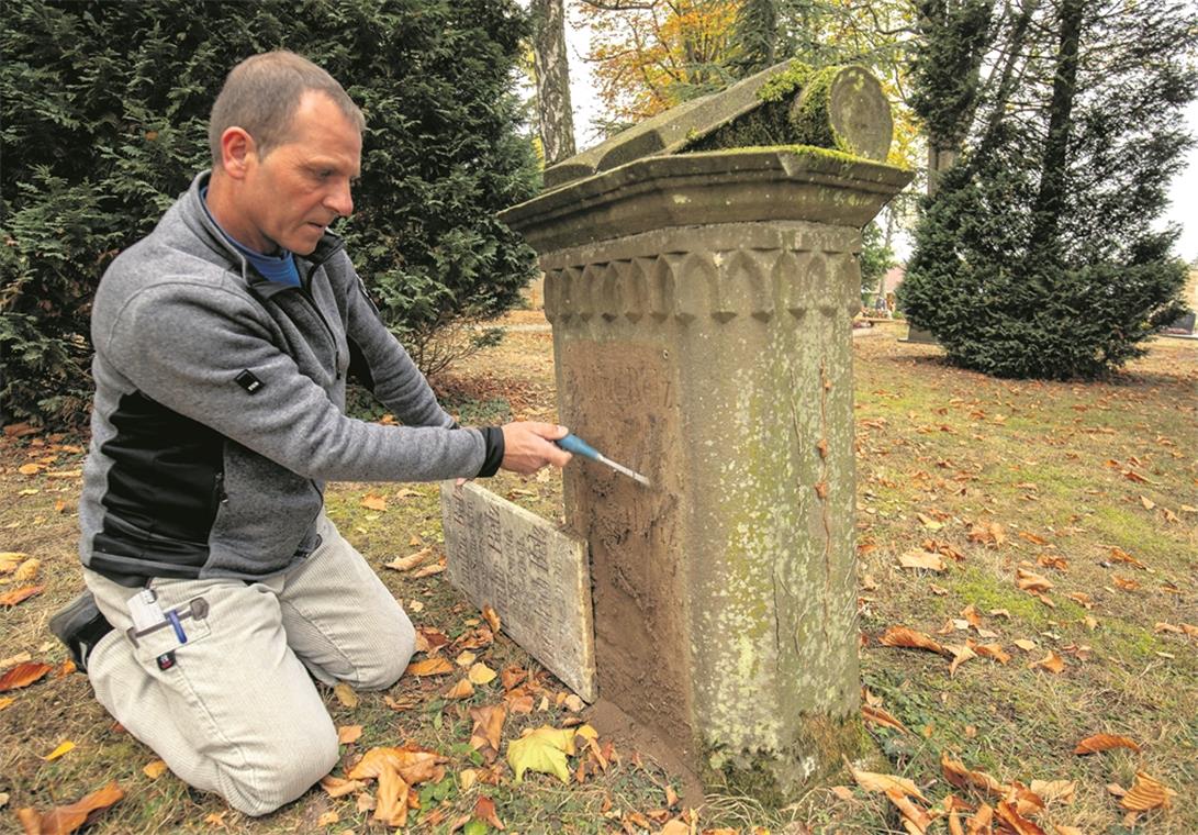 Carl-Eugen Vogt bei der Arbeit: Nachdem er die später angebrachte Tafel entfernt hat, kommt die erste Inschrift zum Vorschein. Fotos: A. Becher