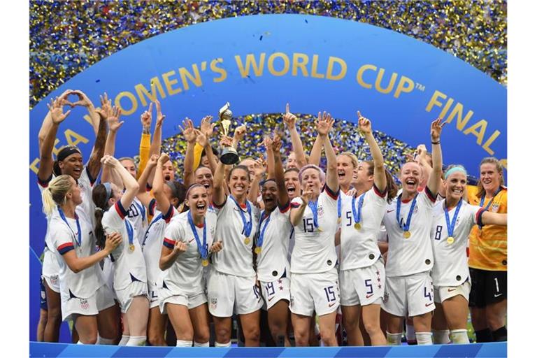 Carli Lloyd (M) hält den WM-Pokal inmitten der jubelnden US-Spielerinnen. Foto: Sebastian Gollnow