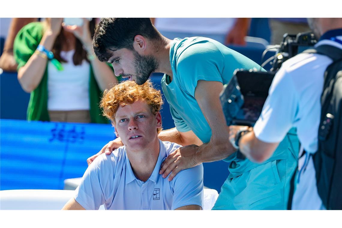 Carlos Alcaraz (r) tröstet Jannik Sinner nach der Aufgabe.