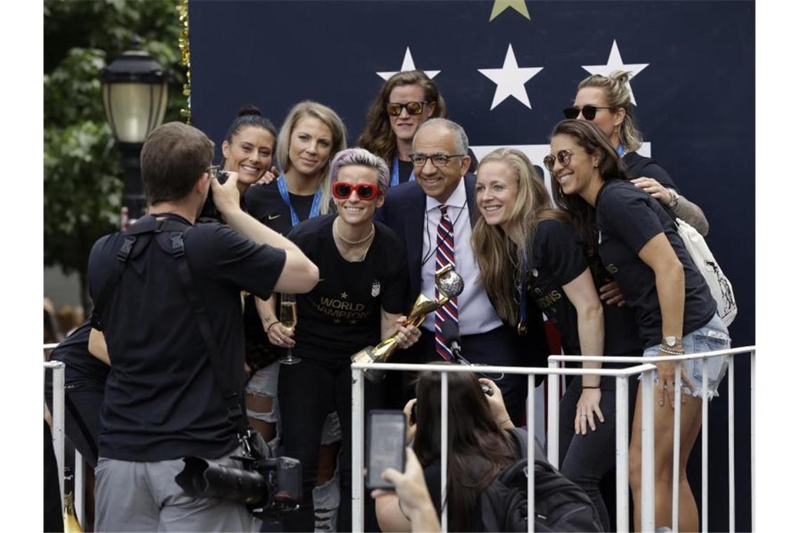 New York feiert Weltmeisterinnen - Rapinoe contra Trump Carlos Cordeiro, Präsident der US Soccer Federation, posiert mit den US-Weltmeisterinnen in New York. Foto: Richard Drew/AP
