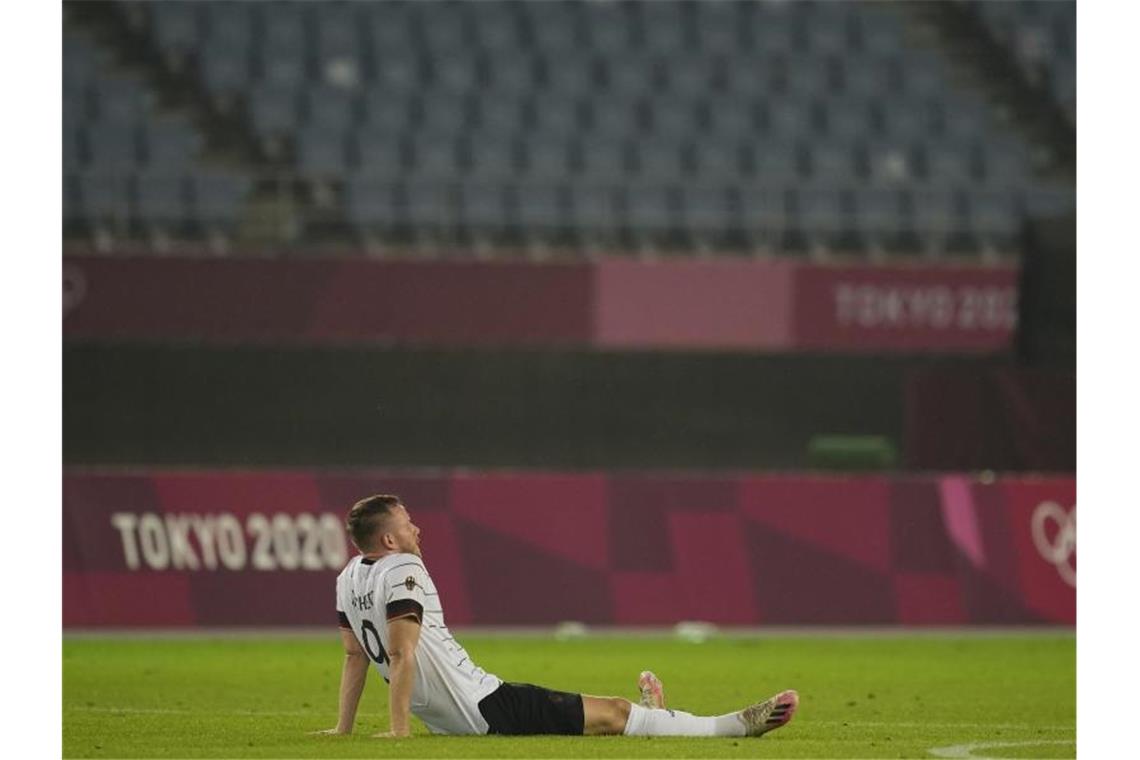 Cedric Teuchert sitzt nach dem Ausscheiden enttäuscht auf dem Rasen. Foto: Andre Penner/AP/dpa
