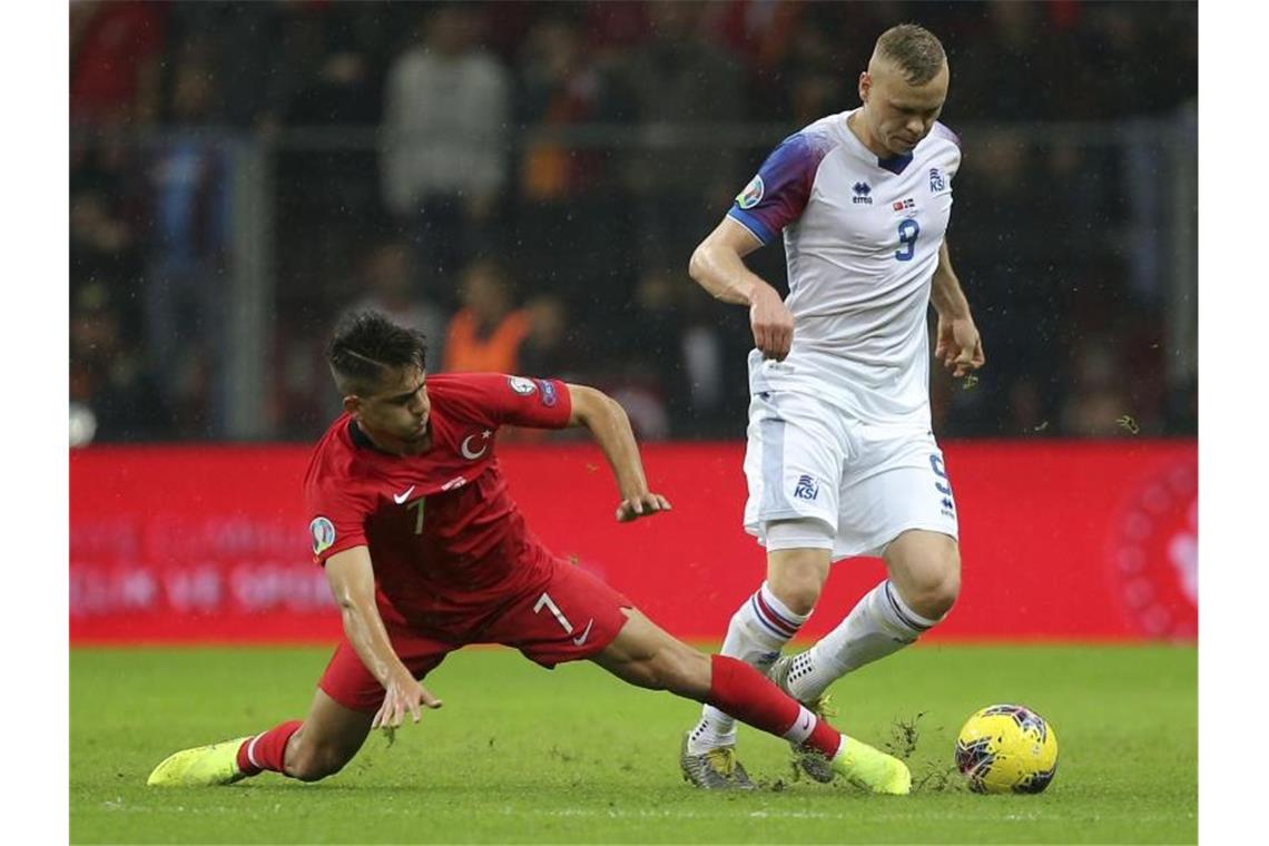 Cengiz Under (l) aus der Türkei und Kolbeinn Sigthorsson aus Island im kämpfen um den Ball. Das Spiel endet 0:0. Foto: AP/dpa