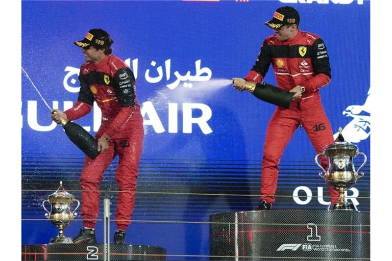 Charles Leclerc (r) feiert auf dem Podium mit seinem Teamkollegen Carlos Sainz. Foto: Hassan Ammar/AP/dpa