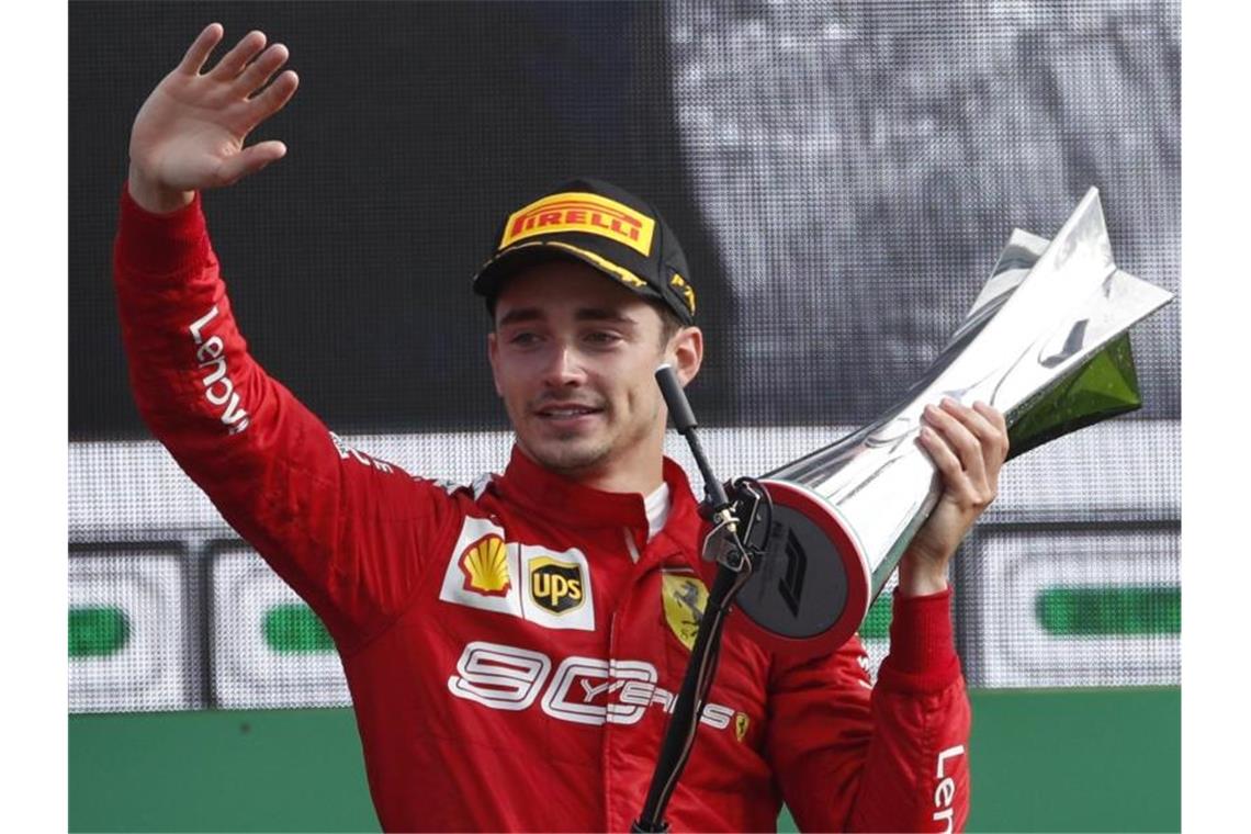 Charles Leclerc vom Team Scuderia Ferrari hält auf dem Podium den Siegerpokal in der Hand. Foto: Antonio Calanni/AP