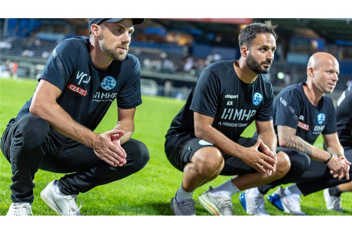 Cheftrainer Marco Wildersinn und seine Assistenten Kerem Arslan und Daniel Lang (v.li.) nach dem Sieg in Aalen vor den Kickers-Fans.