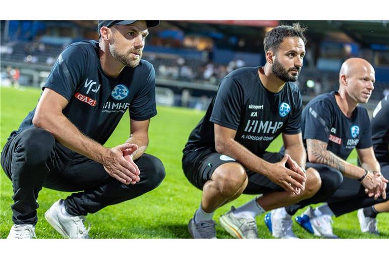 Cheftrainer Marco Wildersinn und seine Assistenten Kerem Arslan und Daniel Lang (v.li.) nach dem Sieg in Aalen vor den Kickers-Fans.