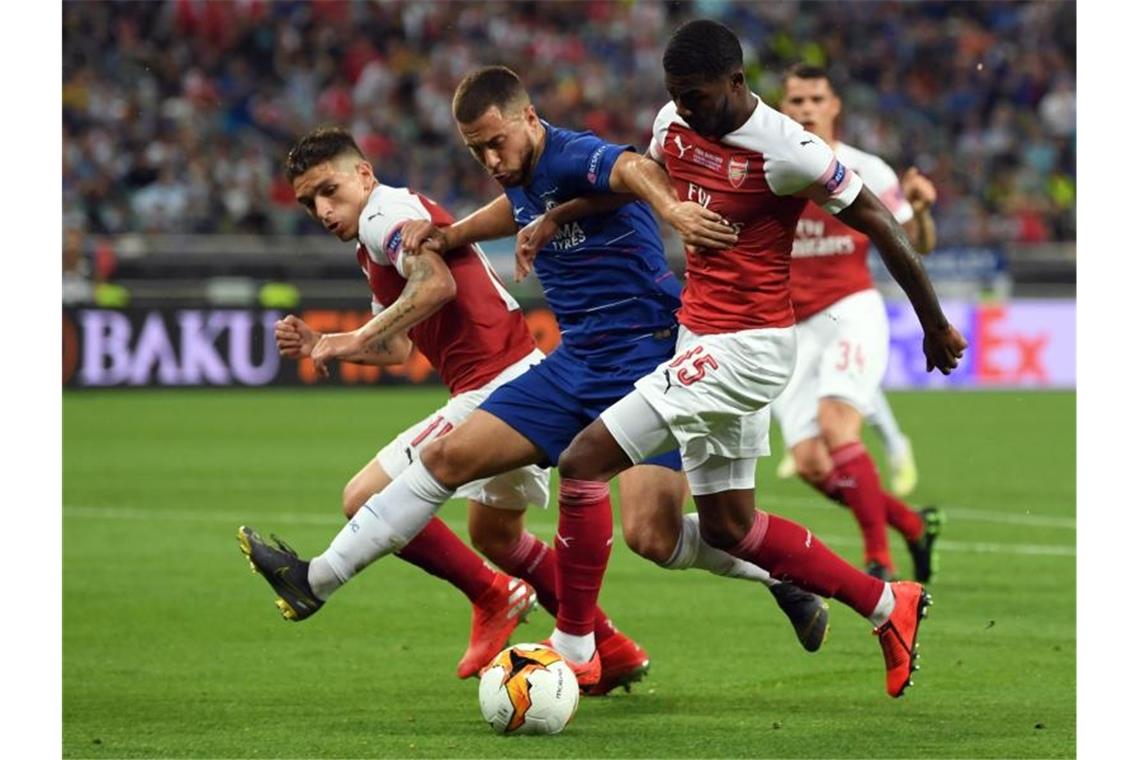 Chelsea-Star Eden Hazard (M) wird von zwei Arsenal-Spielern unter Druck gesetzt. Foto: Arne Dedert