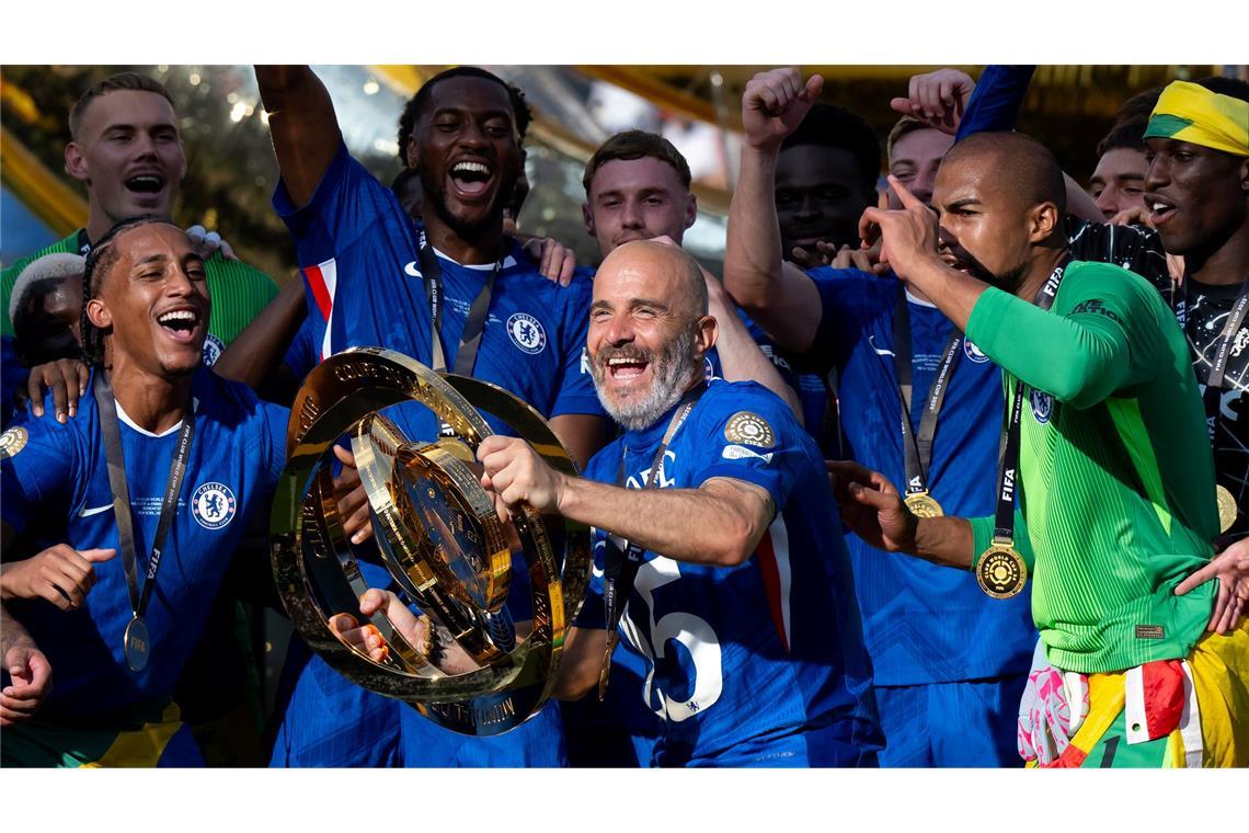 Trump irritiert Chelseas Champions auf dem Siegerpodest Chelsea-Trainer Enzo Maresca (M) jubelt mit der WM-Trophäe. Der Italiener coachte PSG-Trainer Luis Enrique im Finale aus.