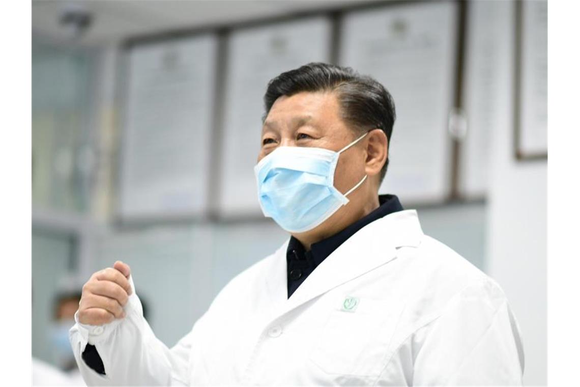 Chinas Präsident Xi Jinping trägt einen weißen Kittel und Mundschutz. Foto: Xie Huanchi/XinHua/dpa