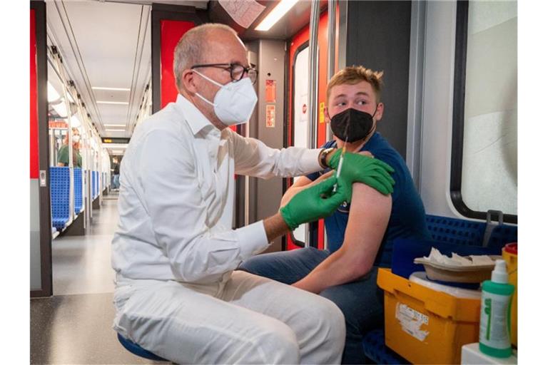 Christian Gravert, Chefmediziner der Deutschen Bahn, verabreicht einem Mann in einer Berliner S-Bahn den Impfstoff des Herstellers Johnson & Johnson. Foto: Christophe Gateau/dpa