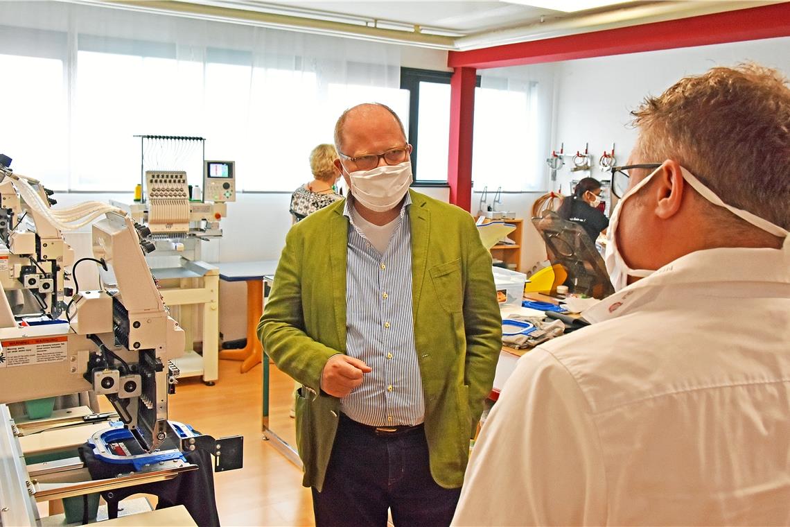 Christian Lange informiert sich im Gespräch mit Michél Lochmann von der Firma Lochmann Berufskleidung über die Maskenproduktion in Backnang. Der Staatssekretär wünscht sich eine Quote für Schutzausrüstung aus heimischer Produktion. Foto: T. Sellmaier