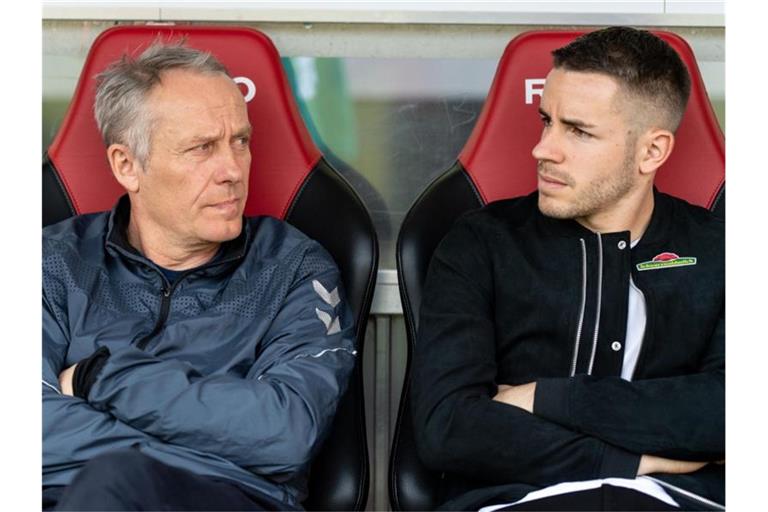Christian Streich (l) und Christian Günter (r) sitzen auf der Bank. Foto: Patrick Seeger/dpa/Archivbild