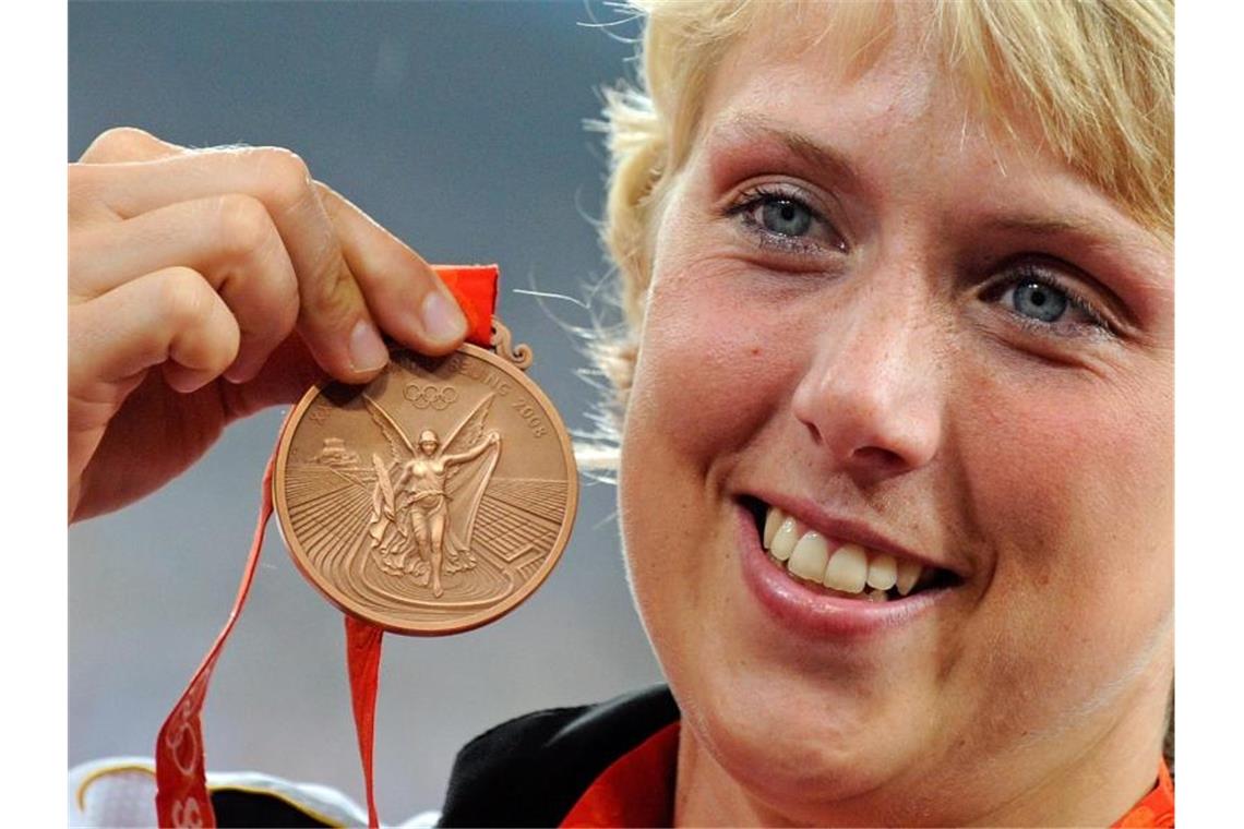 Christina Obergföll zeigt ihre Bronzemedaille im Speerwurf bei den Olympischen Spielen 2008. Foto: Gero Breloer/Archiv