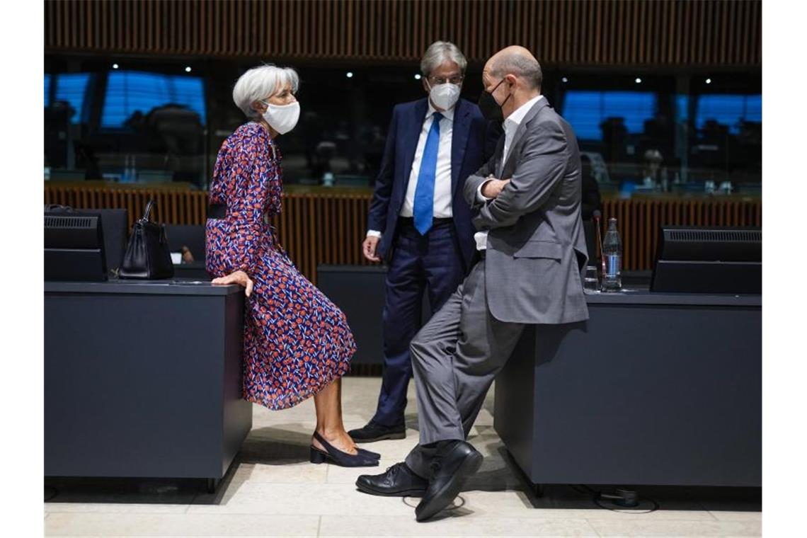 Christine Lagarde, Präsidentin der Europäischen Zentralbank (EZB), im Gespräch mit Bundesfinanzminister Olaf Scholz (r) und EU-Finanzkommissar Paolo Gentiloni. Foto: Francisco Seco/AP Pool/dpa