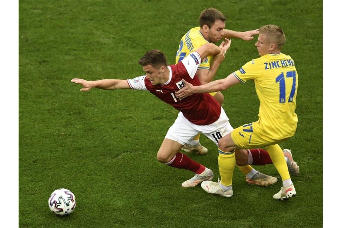 Dank Baumgartner: Österreich erstmals im EM-Achtelfinale Christoph Baumgartner (l) setzt sich gegen die Ukrainer Alexander Sintschenko (r) und Alexander Karawajew (M)durch. Foto: Mihai Barbu/Pool AFP/AP/dpa