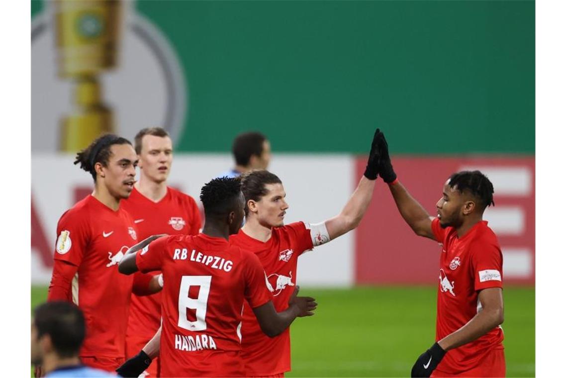 Christopher Nkunku (r) klatscht mit Torschütze Marcel Sabitzer nach dem 2:0 für RB Leipzig ab. Foto: Jan Woitas/dpa