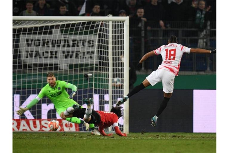 Christopher Nkunku (r) trifft zur 1:0-Führung gegen Hannovers Torwart Ron-Robert Zieler. Foto: Daniel Reinhardt/dpa