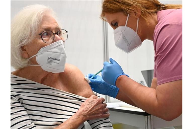 Claudia Kreil (r) vom Impfzentrum am Robert-Bosch-Krankenhaus in Stuttgart verabreicht einer Patientin die Auffrischimpfung gegen das Coronavirus. Foto: Bernd Weißbrod/dpa